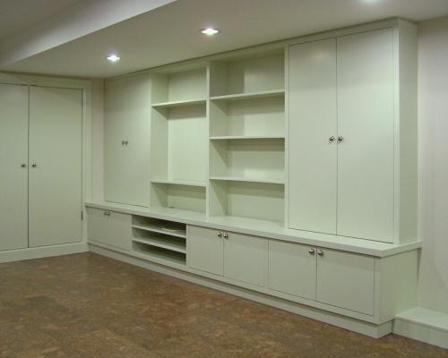 A series of shelves and compartments covering an entire wall. They are white, and empty.