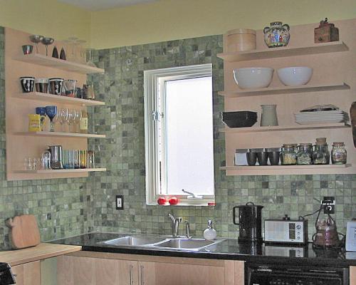 Two shelves attached to walls covered in tiles, on either side of a window.