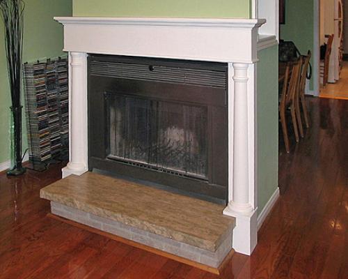 A fireplace with a white, wood mantelpiece.